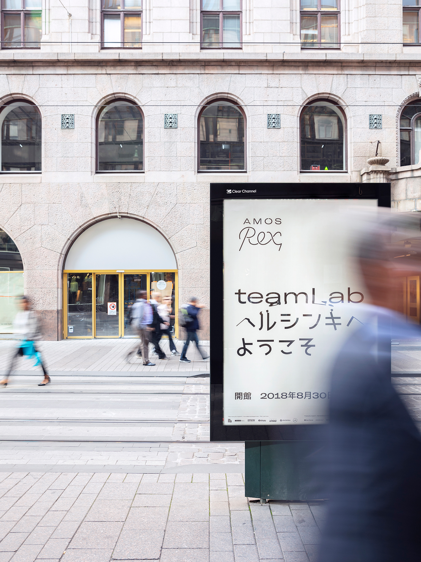 Street-level digital advertising panel for Amos Rex promoting the teamLab exhibition.