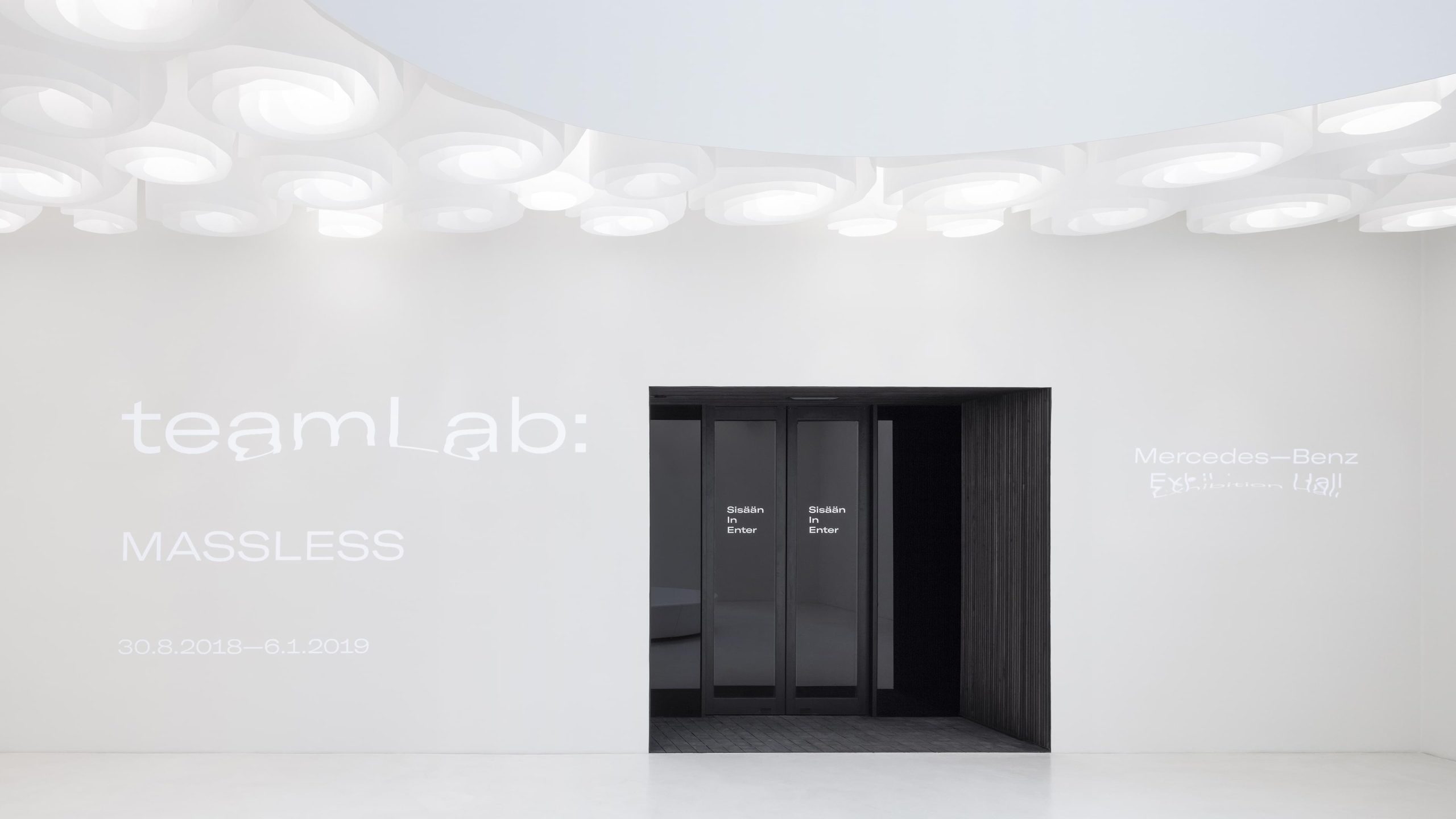 Amos Rex gallery entrance for the 'teamLab: MASSLESS' exhibition, with dark doors set beneath a ring-patterned ceiling.