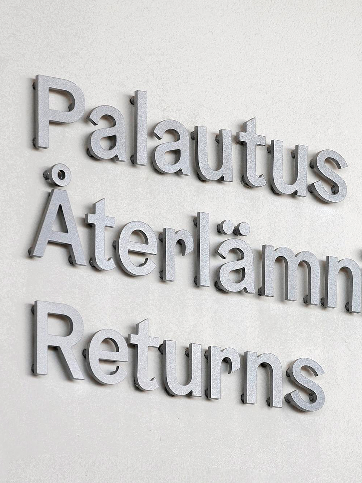 Close-up of raised 3D lettering on a wall at Oodi library.