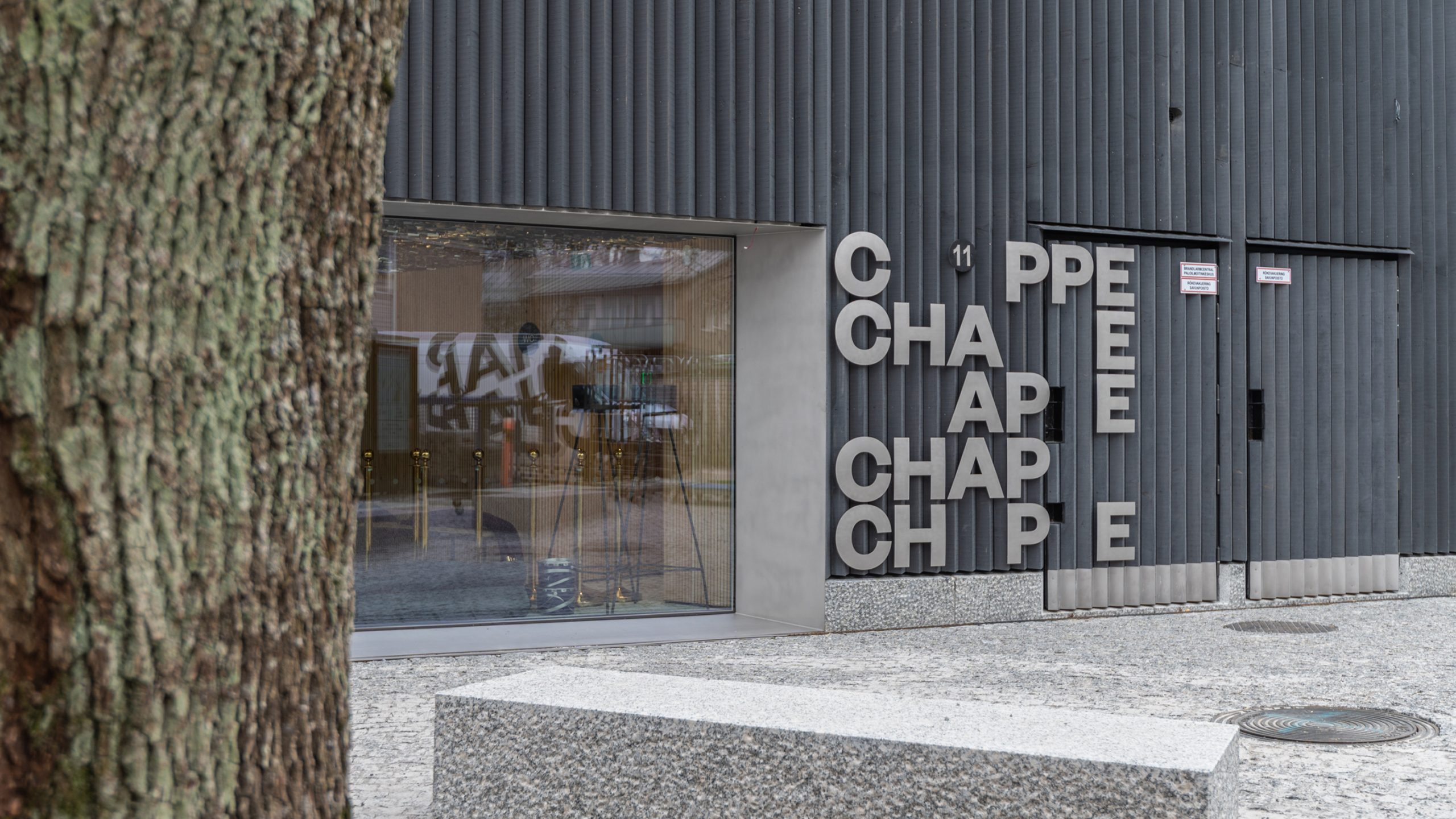 Chappe building exterior with bold stacked silver letters on dark corrugated facade.