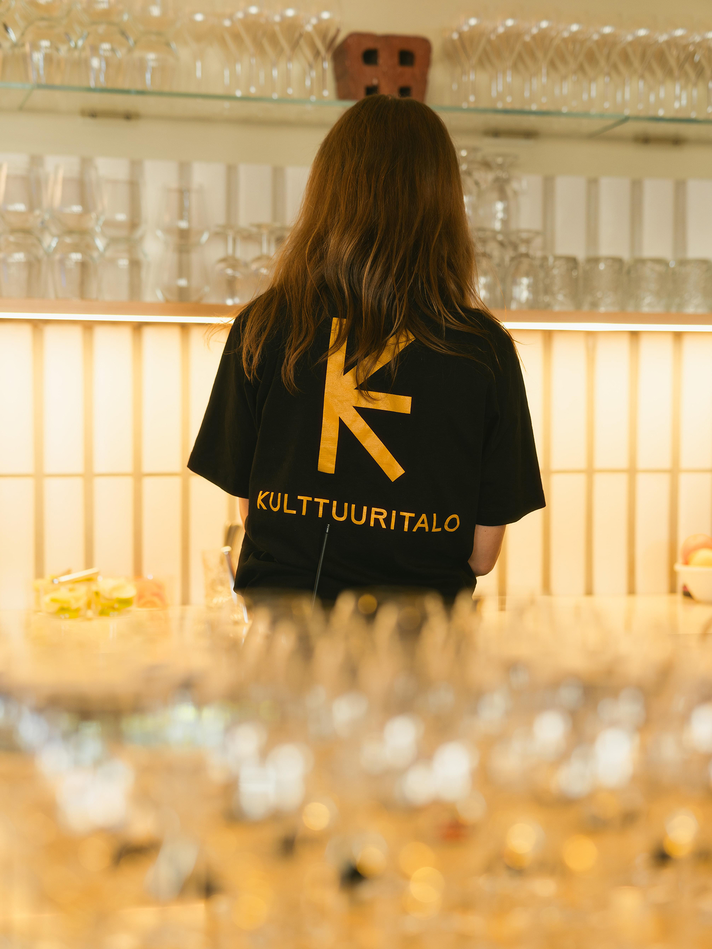 Staff member wearing black Kulttuuritalo branded t-shirt.