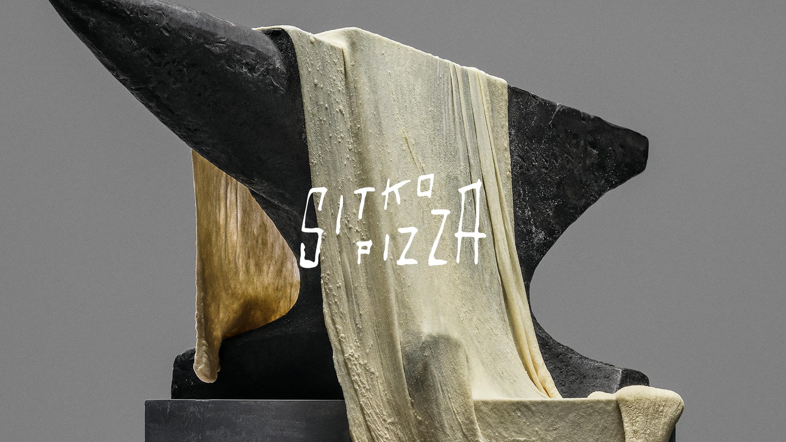 Sitko Pizza brand identity: pizza dough draped over a dark sculptural anvil form against a grey background.