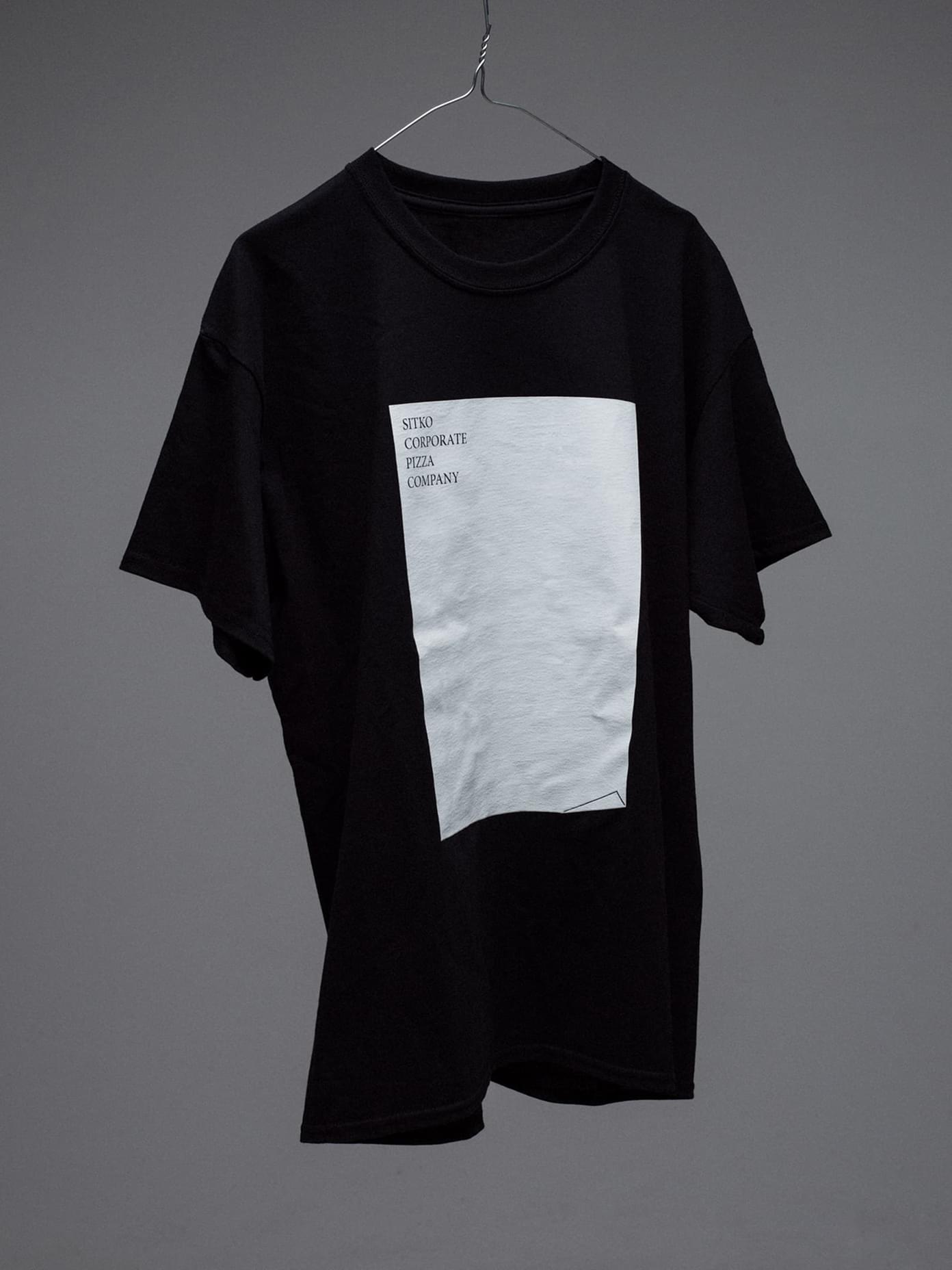 Black t-shirt on wire hanger featuring a white rectangular graphic print.