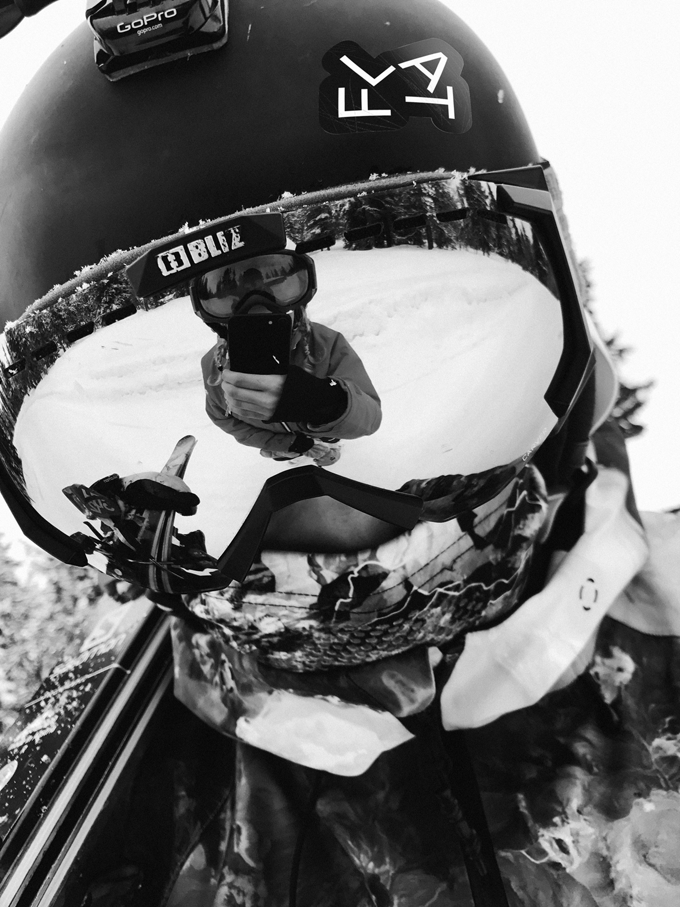 Skier wearing a black helmet with FLAT sticker.