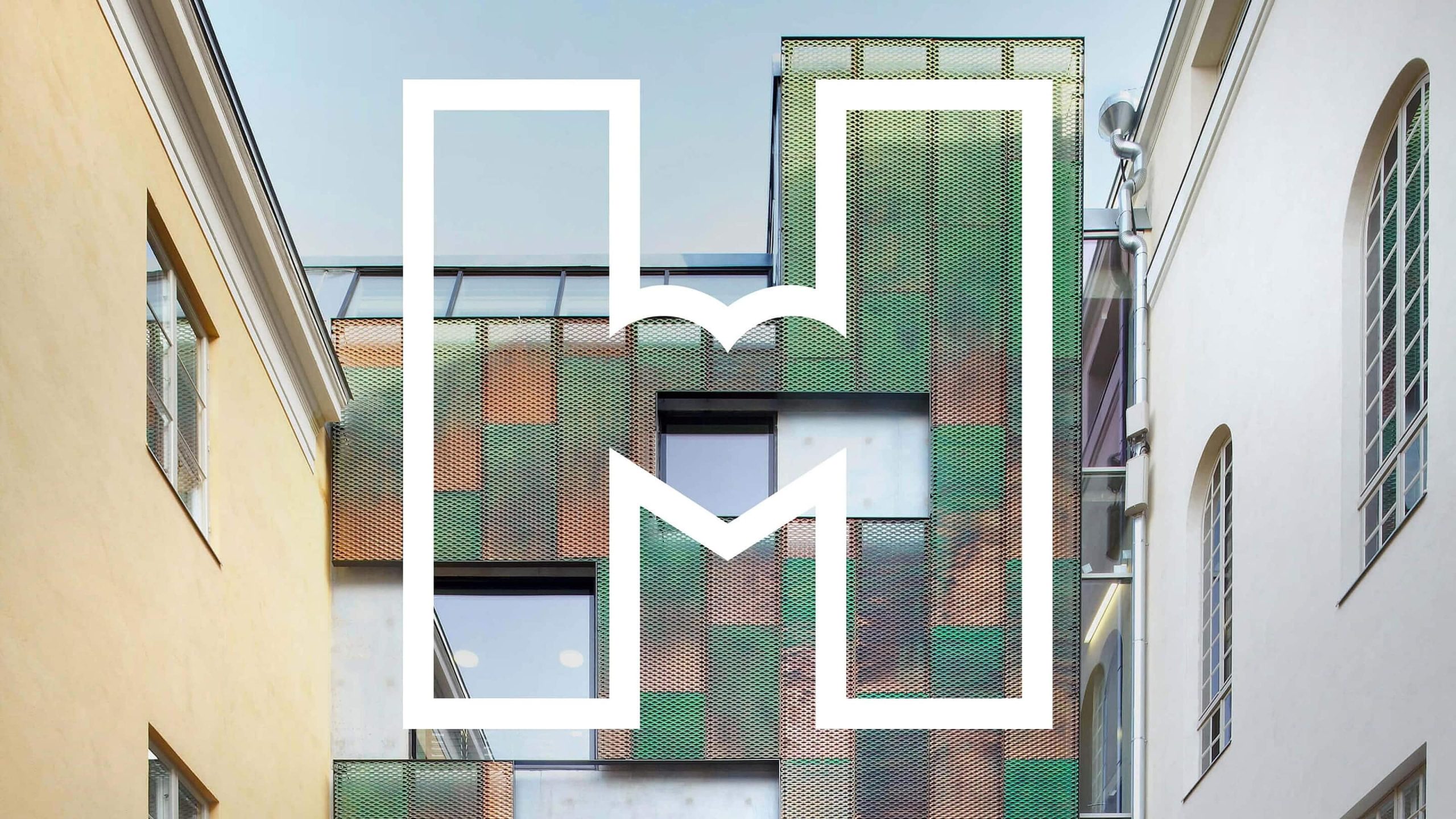 Helsinki City Museum logo overlaid on a colorful perforated metal facade between historic buildings.
