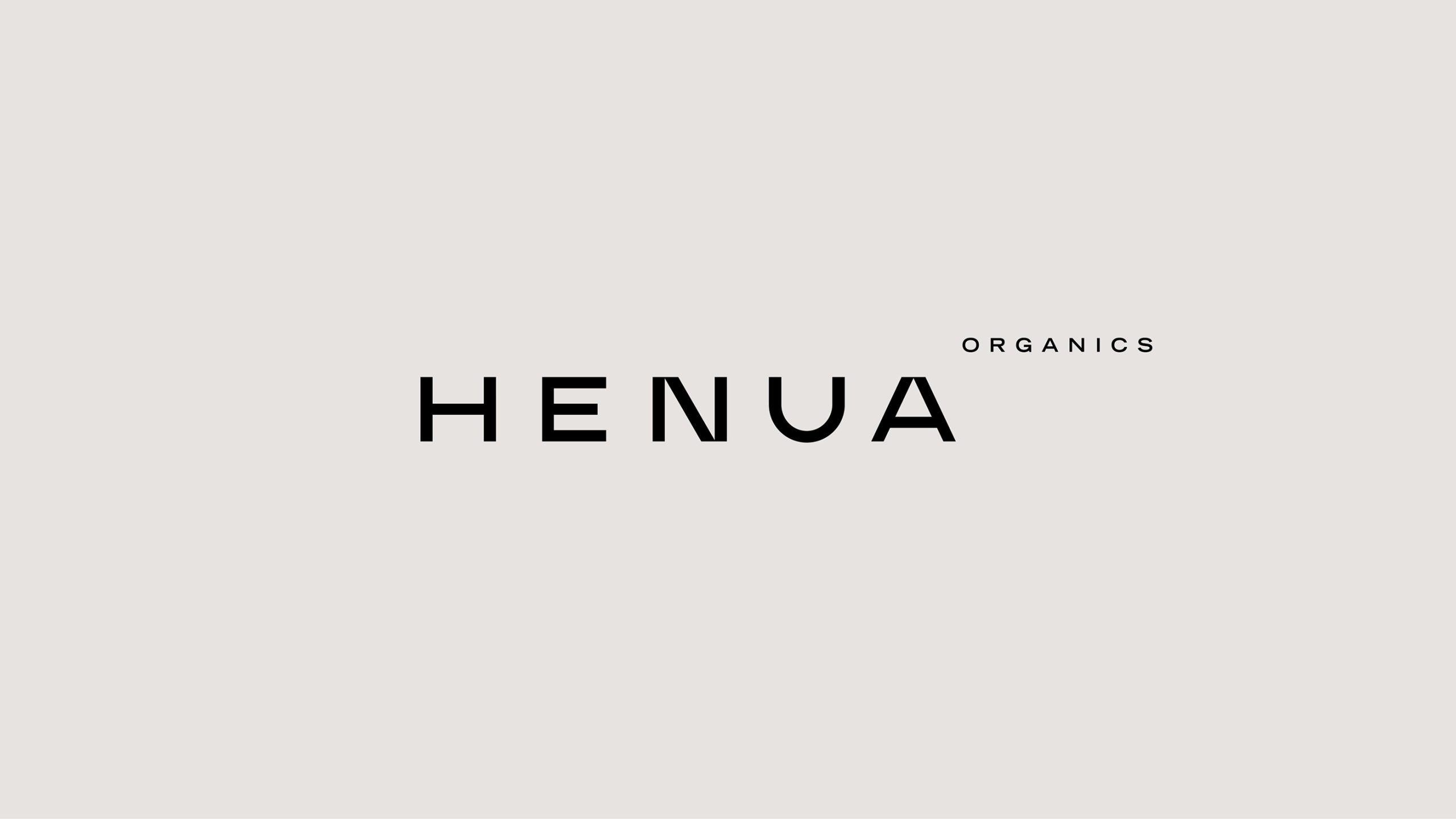 Henua Organics wordmark logo in bold black geometric sans-serif on a warm off-white background.