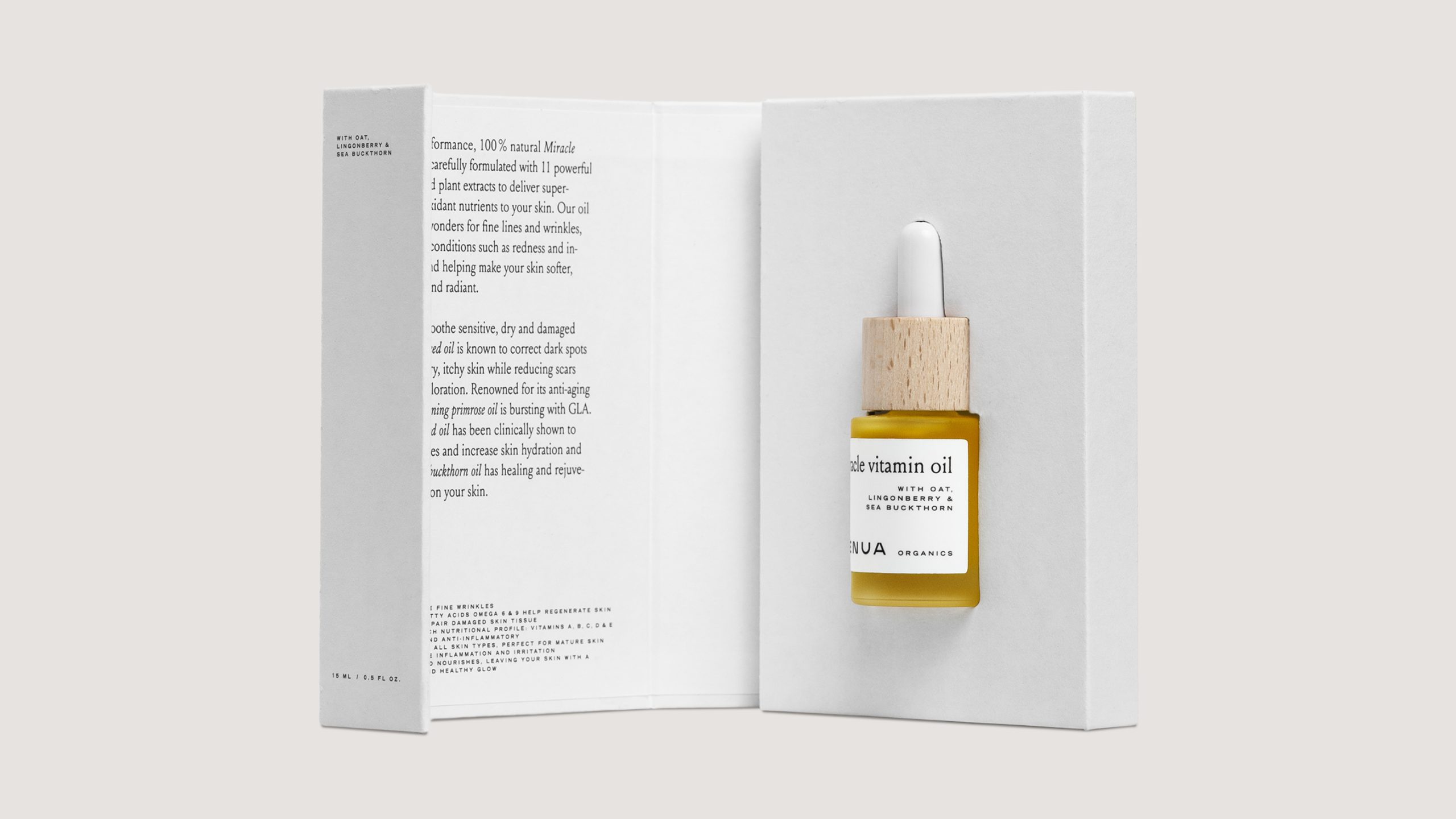 Henua Organics Miracle Vitamin Oil dropper bottle with wooden cap beside open white product box showing description text.