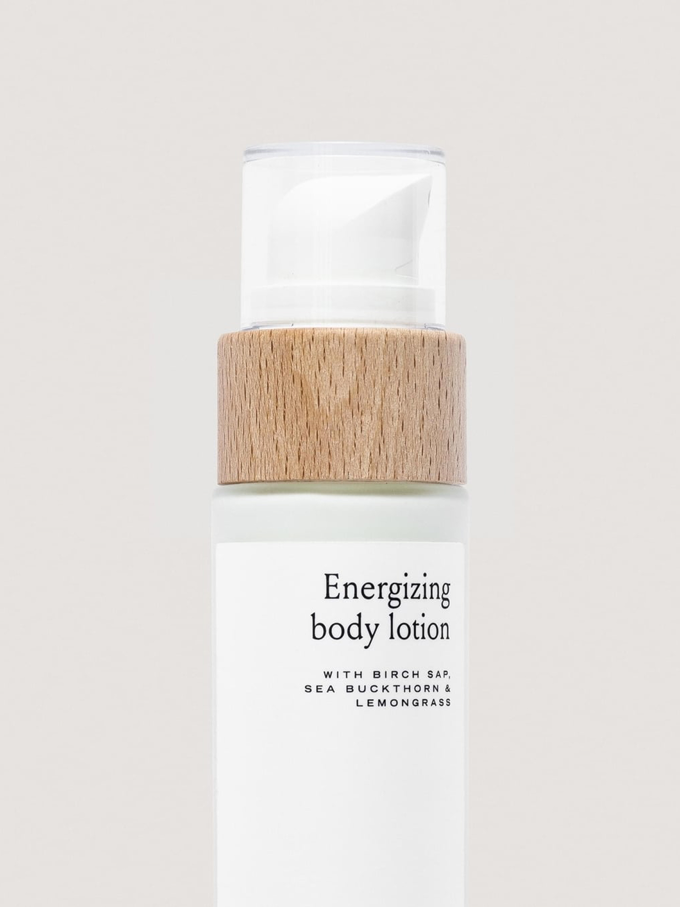Henua Body Lotion pump bottle with natural wood accent and white label.