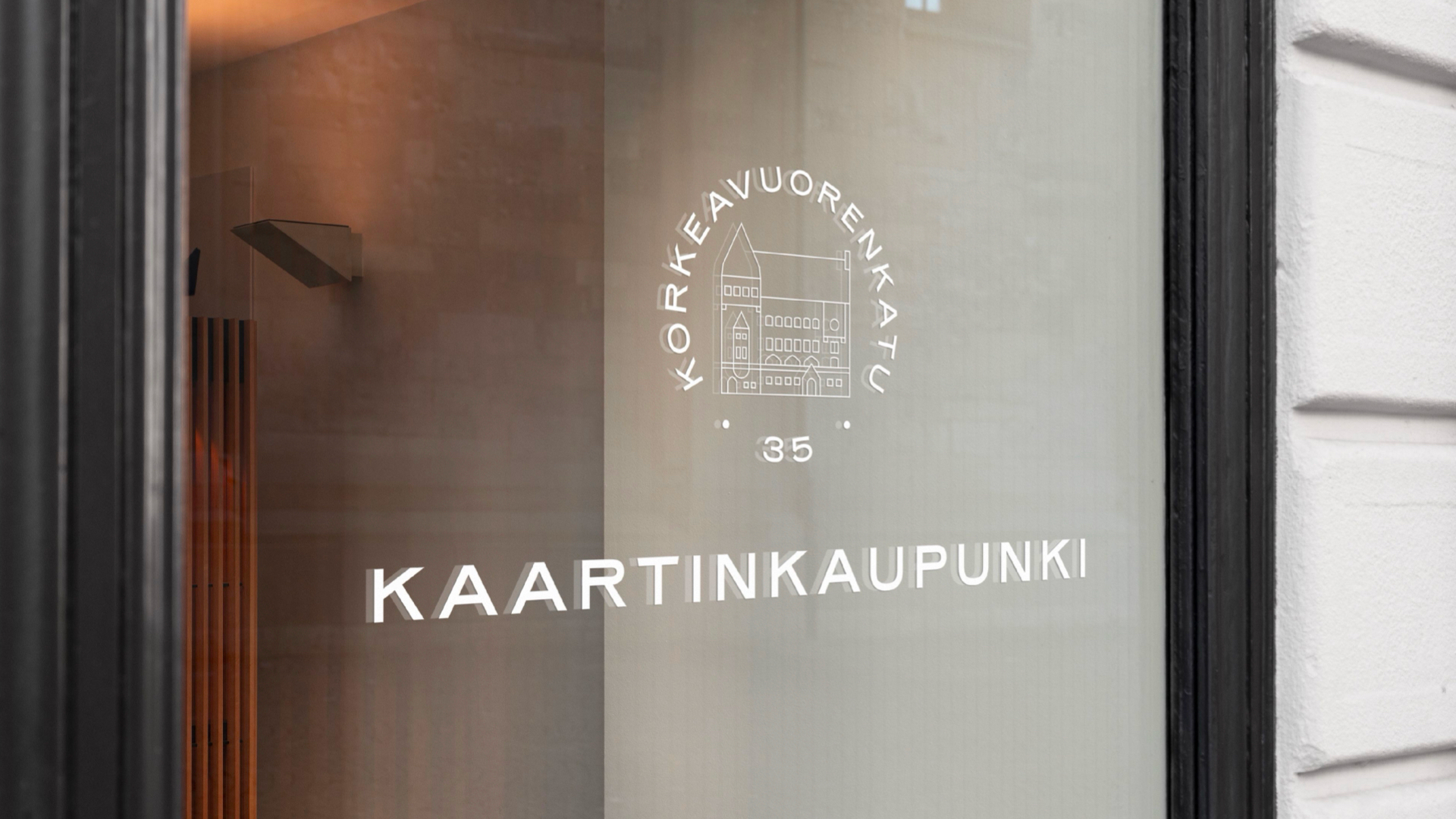 Frosted glass door panel featuring Kaartinkaupunki branding with illustrated building logo.
