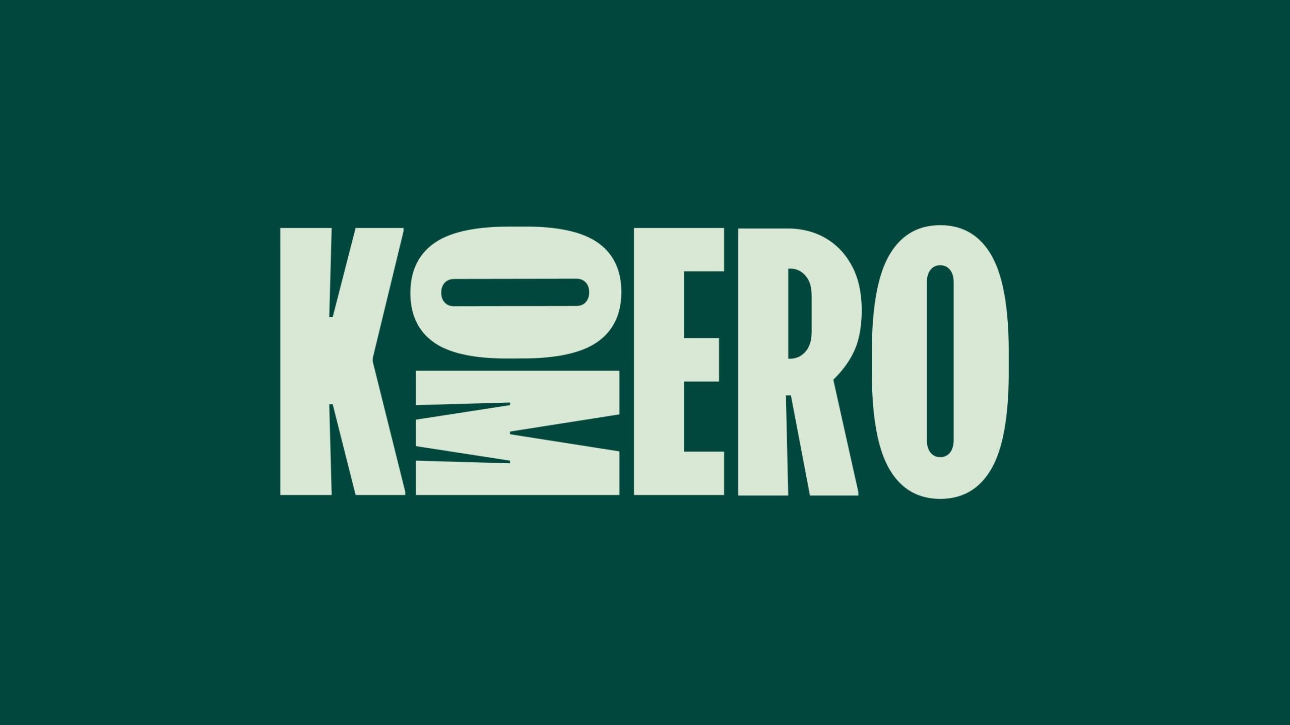 Komero wordmark in pale green on dark teal, with stylised letters featuring geometric cutouts and sharp angular details.