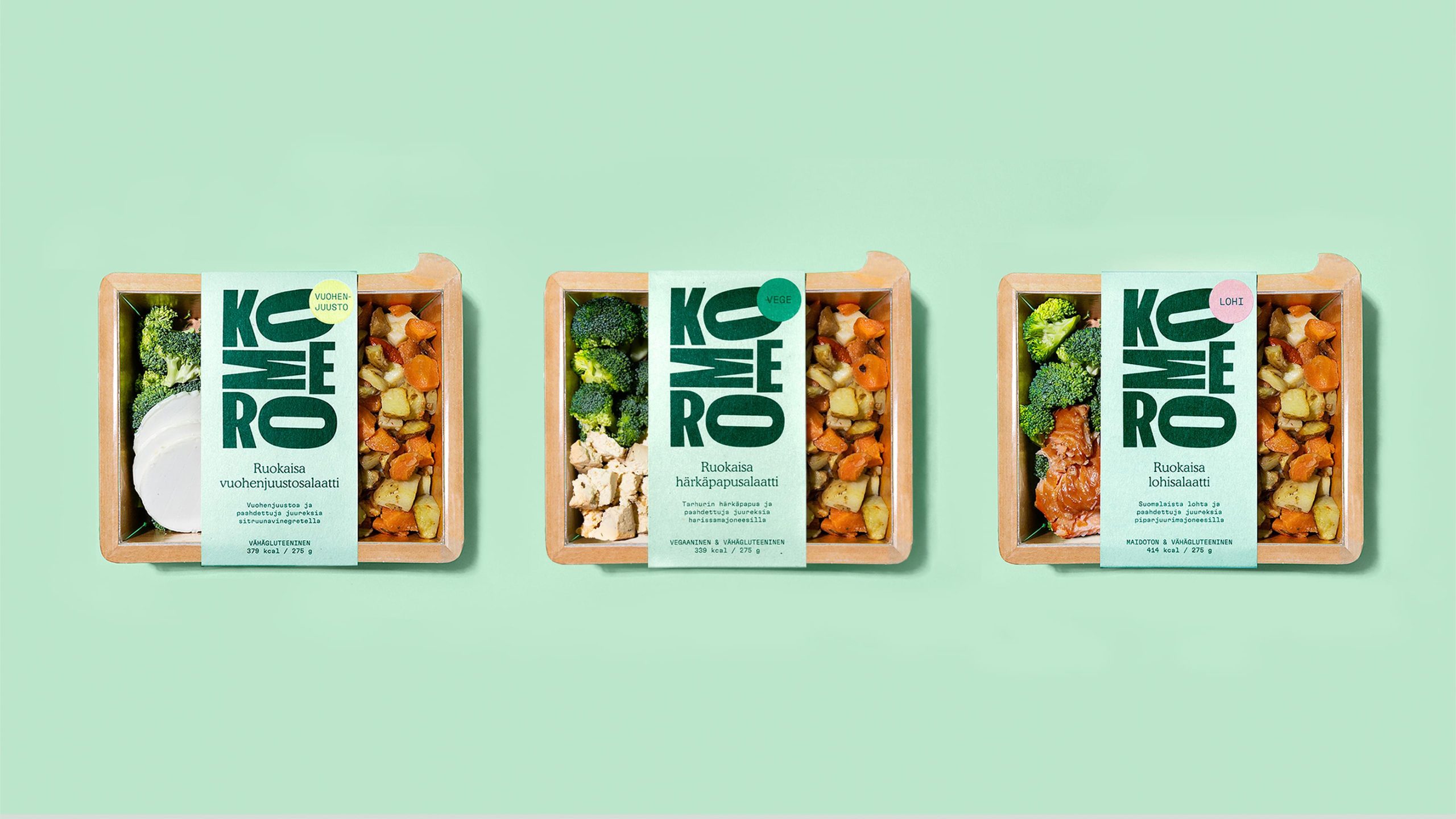 Three Komero ready-meal salad boxes in kraft packaging with bold green KOMERO branding on a mint green background.