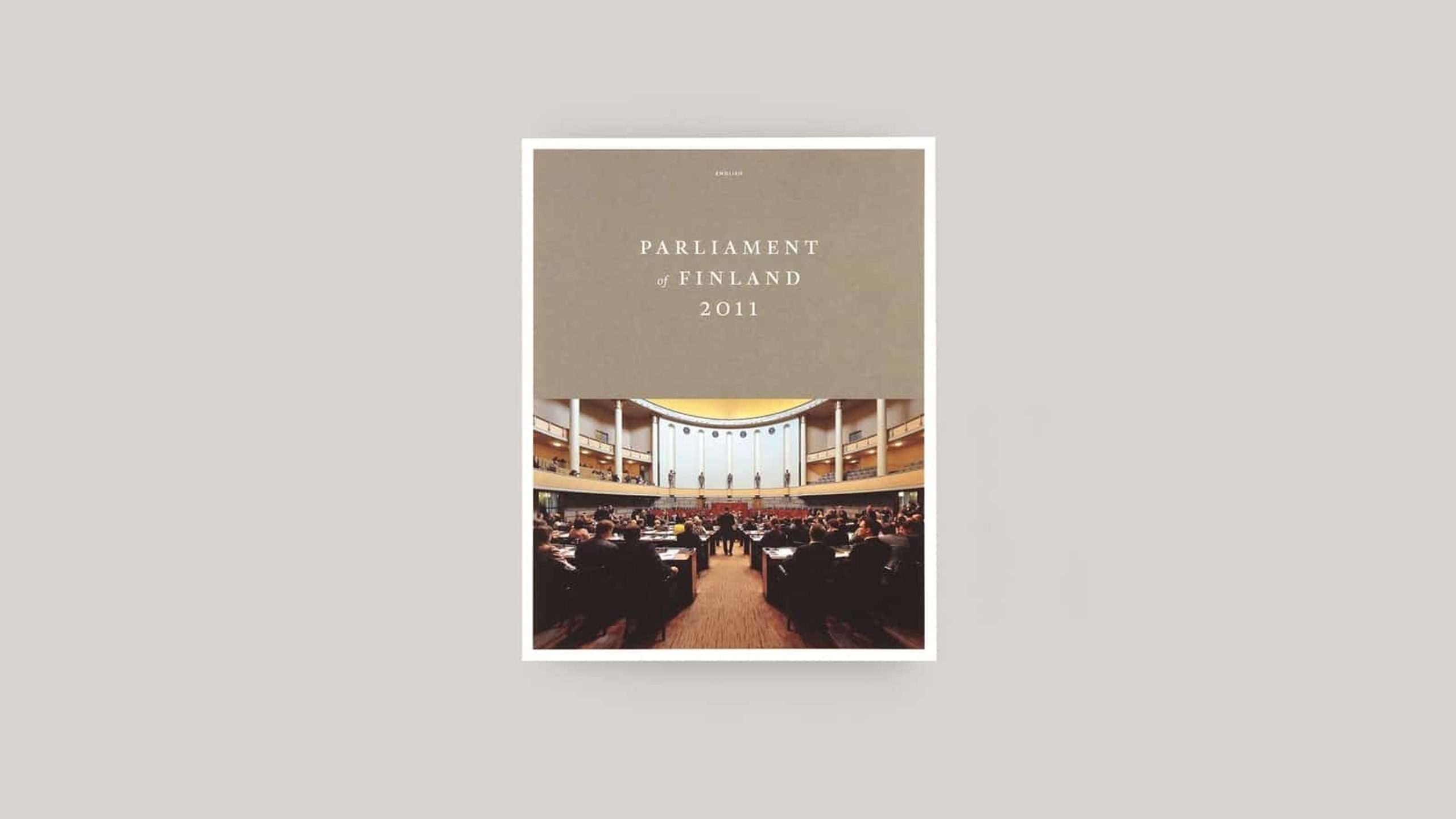 Parliament of Finland 2011 publication cover featuring a photograph of the plenary chamber interior with seated members.