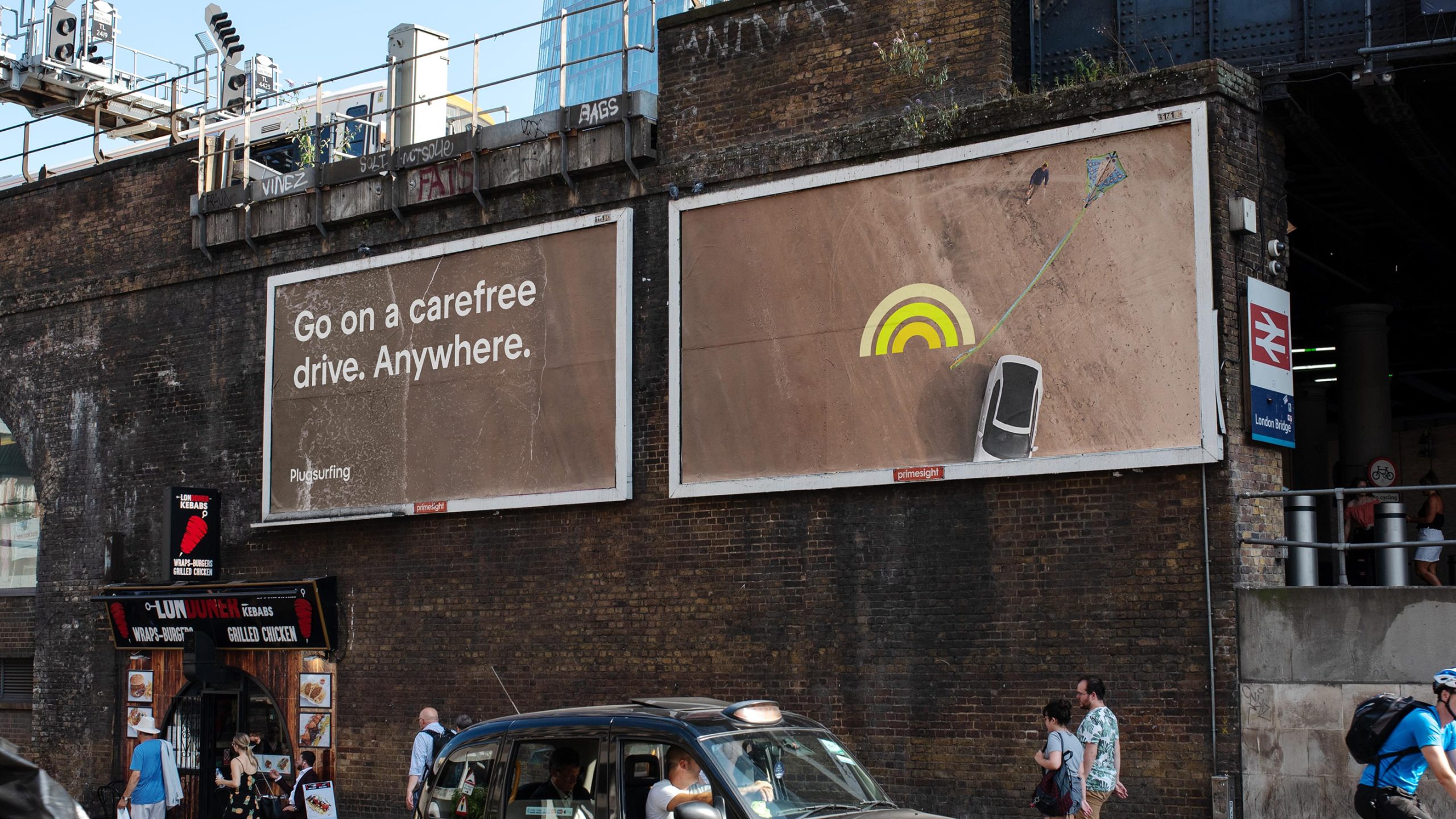 Plugsurfing billboards with aerial car graphic.