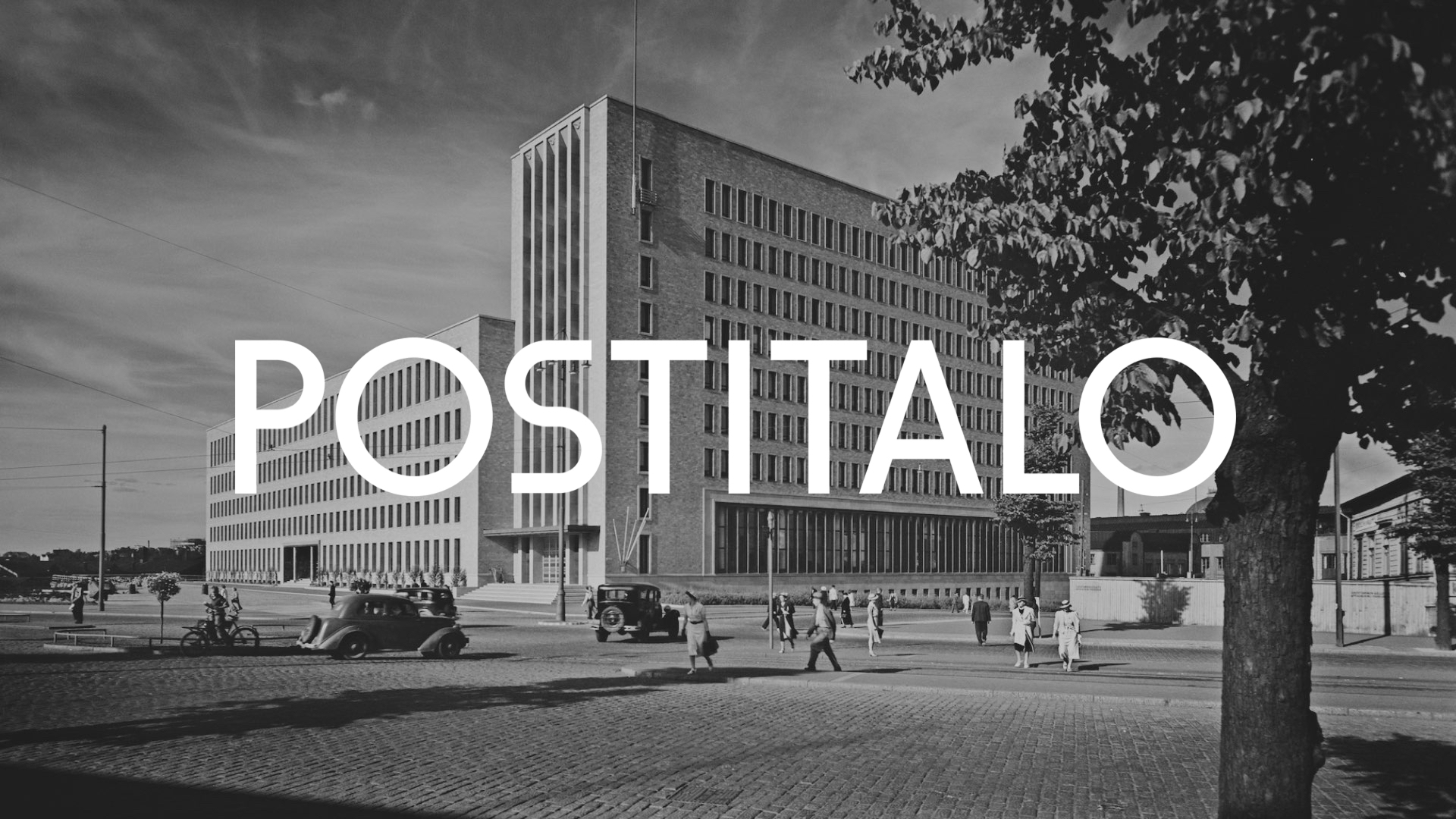 Black and white 1930s photograph of Postitalo, Helsinki's functionalist post office building, with period cars and pedestrians.