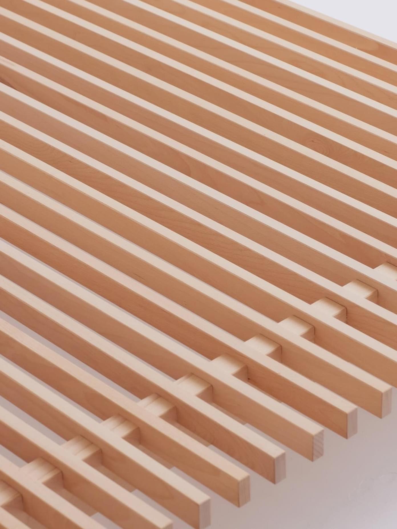 Villa & Peite wooden slatted grating with interlocking joinery detail, light maple finish on white background.