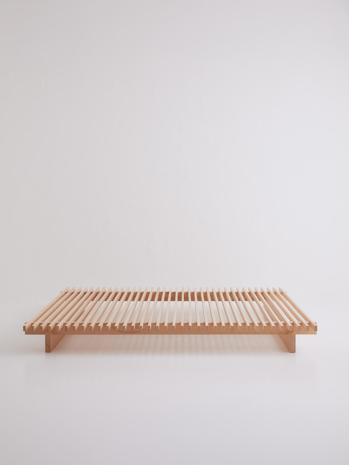 Villa & Peite low slatted wooden bench with natural beech finish, photographed against white background.