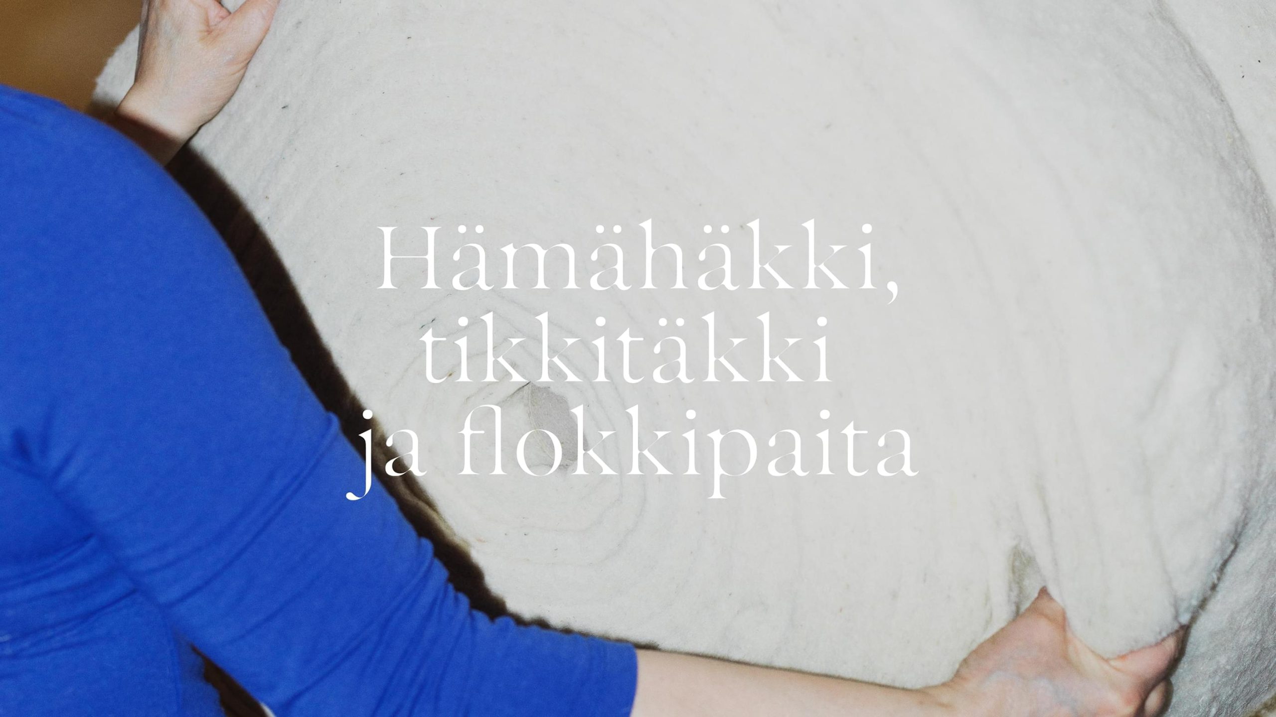 Person in blue top handling a large white wool roll, overlaid.