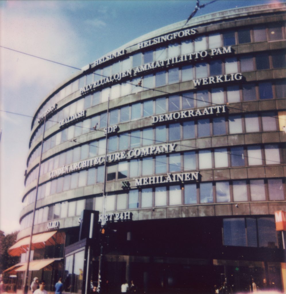 The curved facade of Ympyrätalo in Helsinki, with tenant names in white letters across the floors, Werklig among them